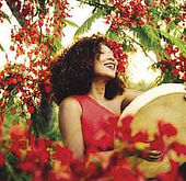 Local Mauritian woman celebrating with traditional drum and flowers