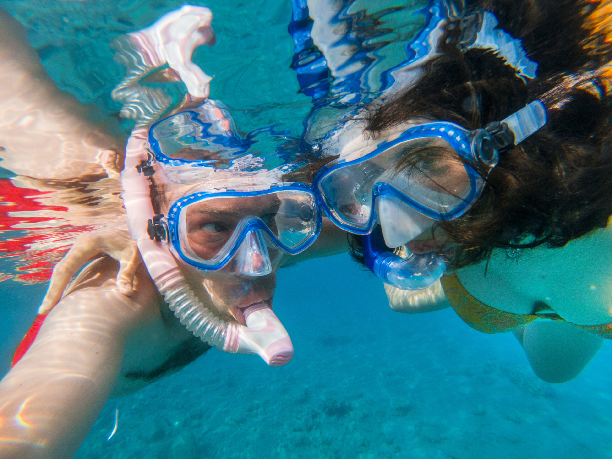 Couple snorkeling hand in hand in the clear waters of Mauritius
