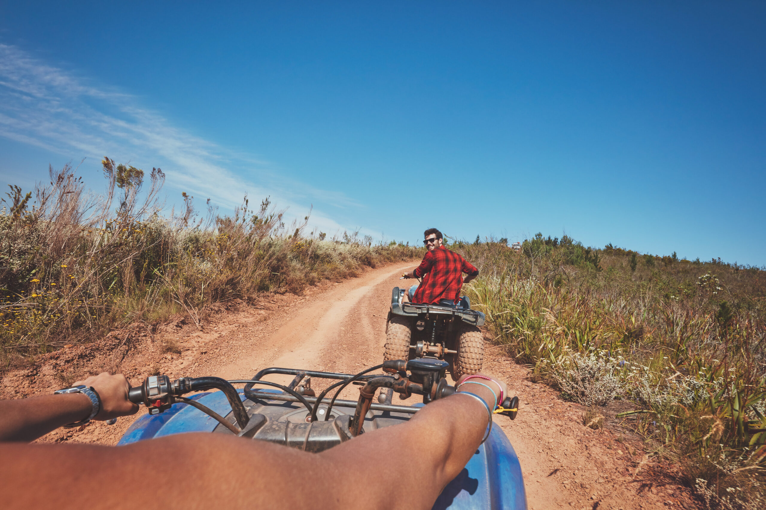 Young man on quad bike. Young man driving all terrain vehicle in nature. View from a ATV.