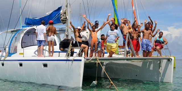 Group enjoying drinks and music on a catamaran to Gabriel Island