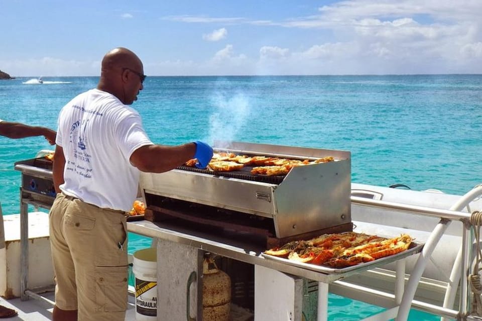 Local chef grilling food on catamaran deck for island lunch