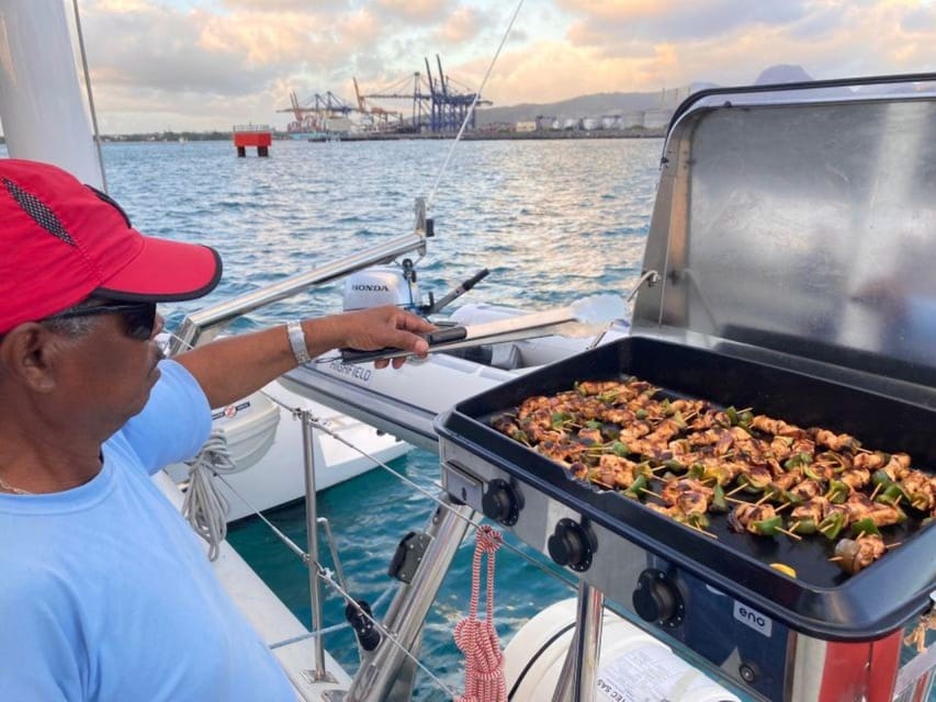 A chef grilling skewers on a catamaran during a Flat Island day cruise in Mauritius
