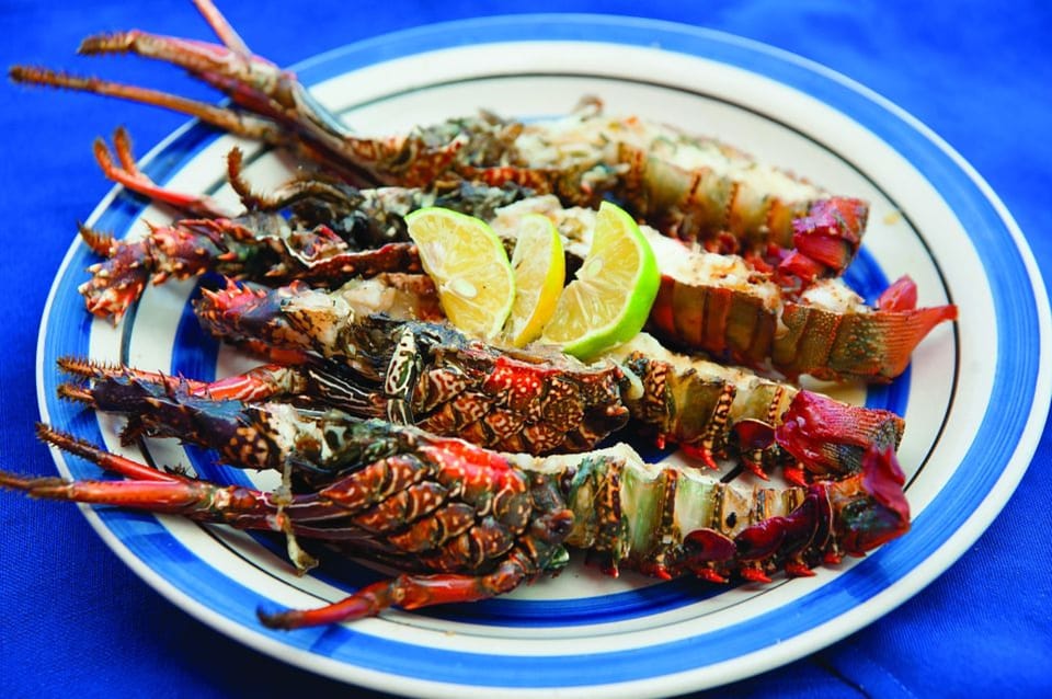 Close-up of grilled lobsters with lemon slices served during the Île aux Cerfs cruise