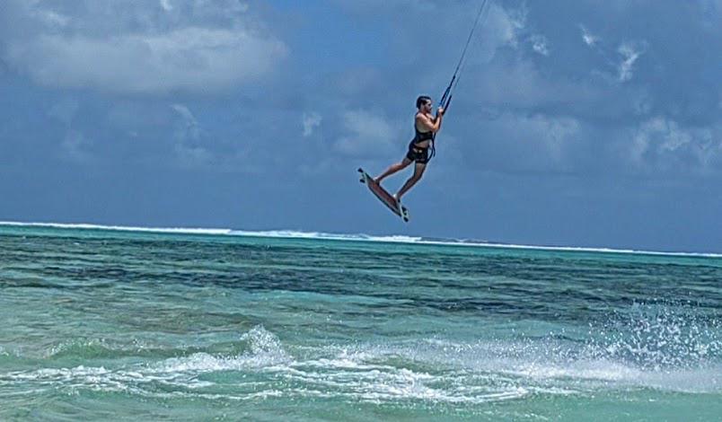 Kitesurfer in mid-air jump over the turquoise waters of Le Morne