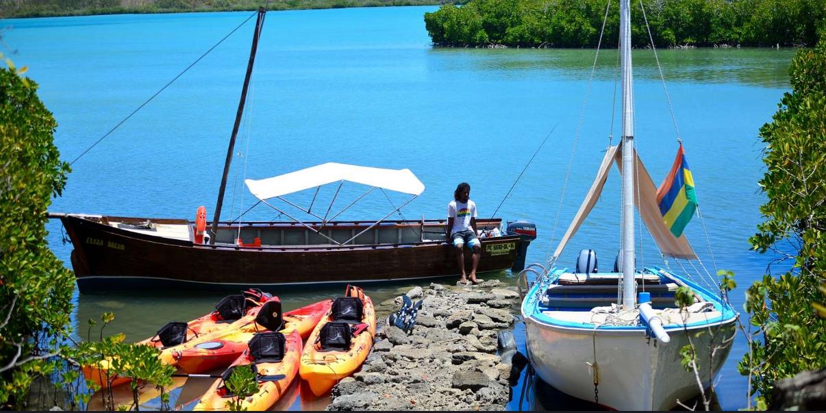 Kayaks docked near sailboats ready for sea kayaking adventure
