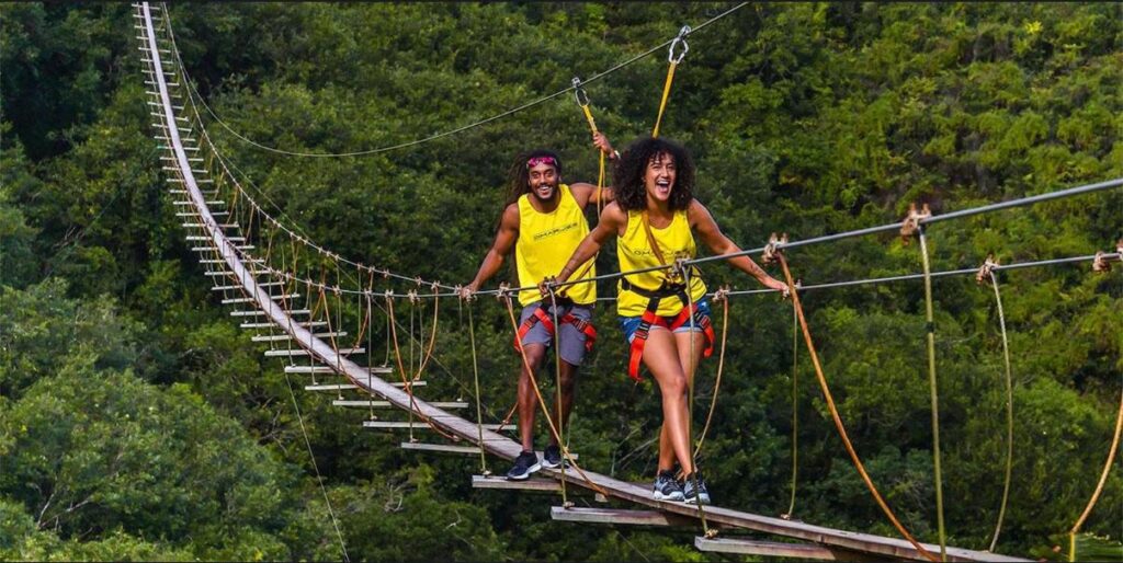 Couple crossing suspension bridge during Mauritius adventure tour