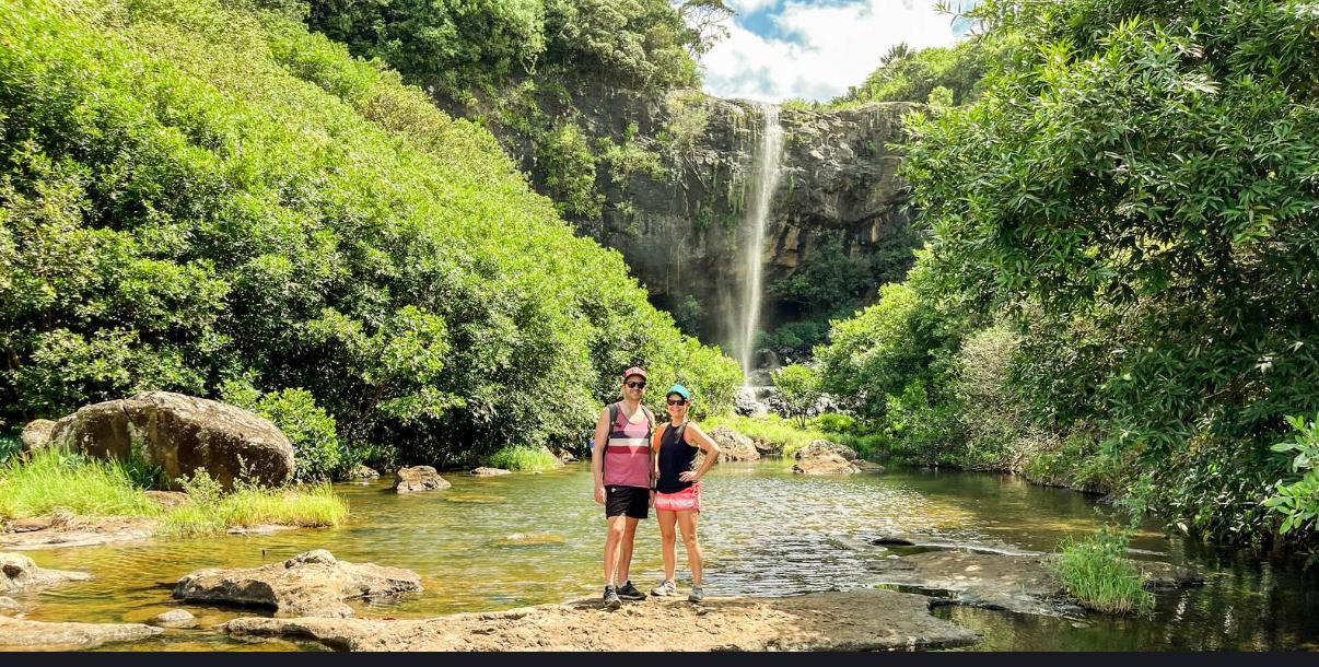 Tourists standing near waterfall at Tamarind Falls during a hiking adventure in Mauritius