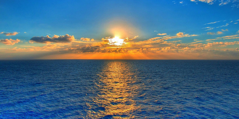 Bright orange and blue sunset view from a catamaran cruise in Grand Bay